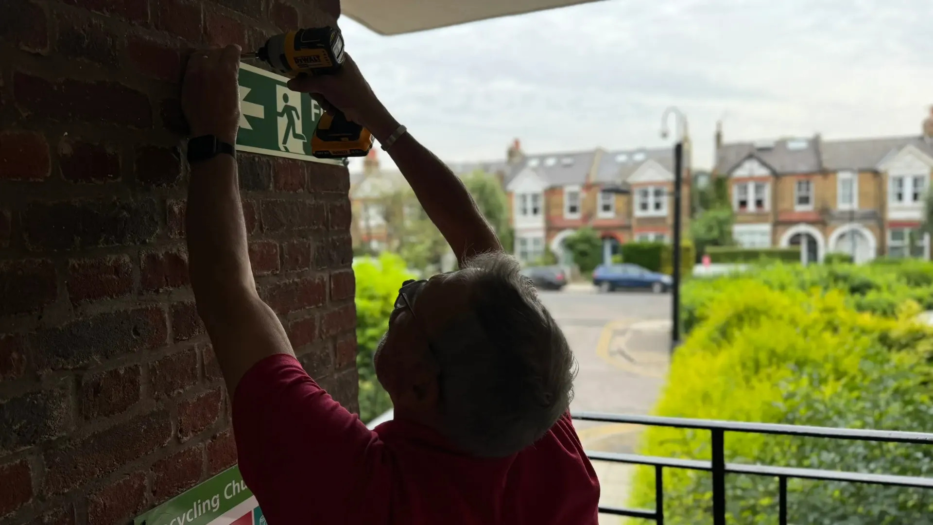 Kings Fire Technician installing fire exit signs into a London premises